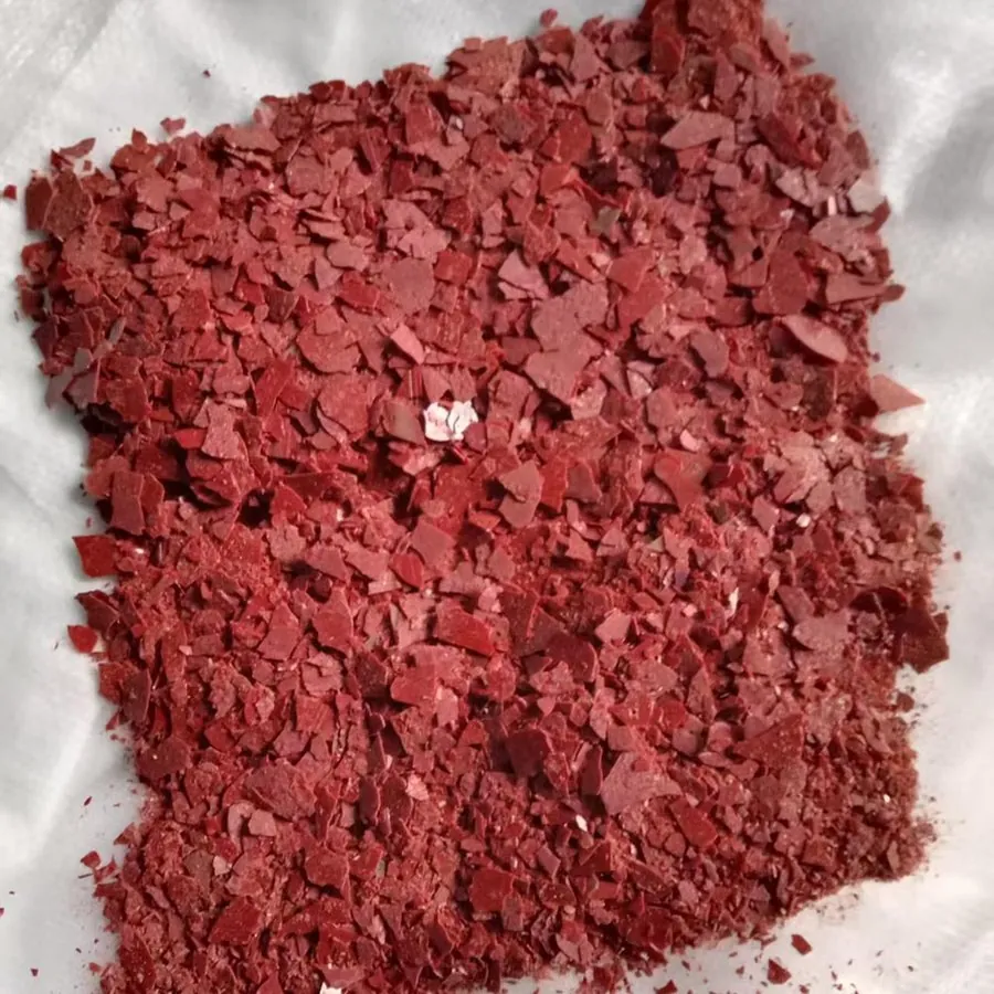 Red sodium sulphide flakes inside open woven bag